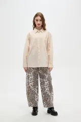 Camisa de algodón con estampado de rayas verticales finas, cuello camisero, cierre frontal con botones y bolsillos frontales tipo parche.