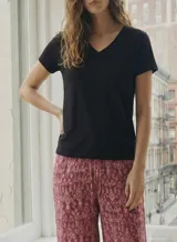 Remera negra de manga corta con escote en V adornado con un borde de encaje o puntilla.