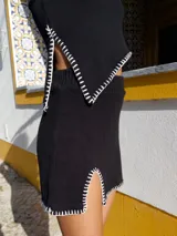 Top tejido negro de algodón con breteles finos y pespuntes blancos.