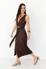 Vestido midi marrón con escote en V, sin mangas y detalle de nudo con aro dorado en la cintura.