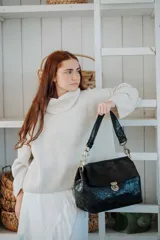 Cartera de hombro con textura efecto cocodrilo en color marrón oscuro. Presenta un diseño rectangular con solapa frontal, cierre metálico a presión y una correa de cadena gruesa en tono dorado.