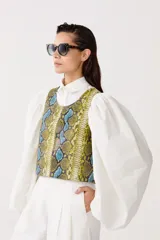 Top sin mangas confeccionado en cuero de oveja con estampado de piel de serpiente en tonos amarillo, azul y negro.