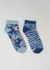Pack de dos pares de medias tobilleras de algodón. Un par celeste con estampado de flores y hojas en azul, rosa y amarillo. El otro par celeste con estampado de cebra en azul.