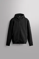 Sudadera hoodie relaxed fit Zara Athleticz confeccionada en tejido técnico compacto elástico con mezcla de algodón, de color negro. Cuenta con cuello subido con capucha, manga larga con bolsillo lateral, bolsillos frontales con acabado termofijado y cierre de cremallera, acabados con rib del mismo tejido, cierre frontal con cremallera de doble dirección y detalle de logo estampado en el bajo.