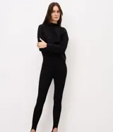 Pantalón legging negro de punto acanalado con estribo en el talón y cintura alta, de corte ajustado al cuerpo.