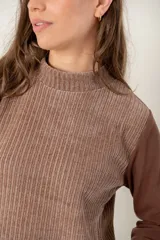 Polera de manga larga con diseño combinado, presentando un cuerpo de textura acanalada en tono marrón claro y mangas lisas en un tono marrón más oscuro. Posee cuello alto y corte recto.