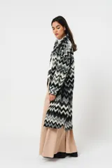 Tapado largo de lana con estampado zigzag horizontal en tonos grises y negros, de manga larga y abotonado.