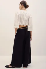 Pantalón negro de corte ancho y relajado, con tiro alto y bolsillos laterales.