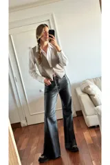 Chaleco de cuero ovino color visón con pasamanería en gamuza al tono y lazos de ajuste frontales.