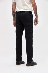 Jean de corte slim, color negro, con diseño de cinco bolsillos, cierre frontal con botón y cremallera.