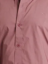 Camisa de manga larga color azul marino, confeccionada en algodón, con cuello abotonado (button-down) y un pequeño logo bordado en el pecho.