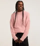 Suéter de punto color crema con cuello redondo y mangas largas ajustadas. Modelo slim alargado con efecto de pelitos.