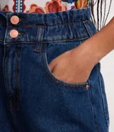 Short de jeans azul oscuro, corte holgado, cintura alta con elástico y trabillas, cierre con botón y cremallera, bolsillos y ruedo doblado.
