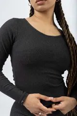 Remera de manga larga color marrón, confeccionada en tejido acanalado, con cuello redondo y ajuste al cuerpo.