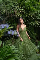 Vestido largo verde oliva de gasa, con escote en V, breteles finos y falda con volados escalonados.