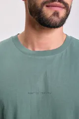 Remera verde con estampa en la espalda que simula una pantalla de computadora con carpetas, archivos, mensajes de error y la leyenda 'Scanning...'.