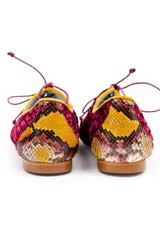 Zapatos tipo oxford de terciopelo rayado en color granate, con detalles de cuero con estampado de piel de serpiente en el talón y la puntera. Presentan cordones finos y ribetes en color amarillo.