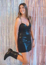 Vestido negro de fiesta, corte mini, con top tipo corsé con costuras fruncidas y breteles finos que se atan en la espalda. Elástico en la cintura trasera.