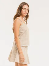 Musculosa de lino a rayas verticales azules y blancas, con breteles anchos y ruedo con flecos.