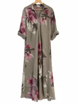 Vestido largo color visón con estampado floreado en tonos fucsia y verde, corte camisero con cuello solapa, cierre frontal parcial con botones y mangas largas con vuelta.