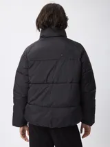 Campera puffer de nylon color negro, con cuello alto, cierre frontal con cremallera y botones a presión. Presenta bolsillos frontales con solapa y diseño acolchado.