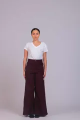 Pantalón de corte wide leg confeccionado en pana acanalada color marrón chocolate. Presenta tiro alto, cierre frontal con botón y bolsillos laterales.