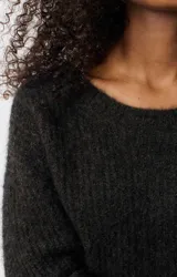 Sweater de punto con cuello a la base y mangas largas, de corte holgado y diseño tipo globo. Confeccionado en una mezcla de lana y alpaca, presenta una textura suave y mullida.