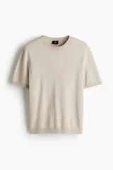Remera de punto fino color beige, de corte ajustado, con cuello redondo ribeteado, mangas cortas y dobladillo recto.