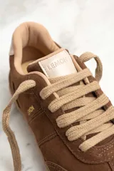 Zapatillas bajas de gamuza color marrón con cordones y suela de goma color caramelo.