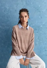Sweater de tejido de punto tostado, con mangas amplias y acampanadas, cuello redondo y diseño holgado con textura horizontal.