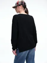 Sweater de punto amplio en viscosa liviana con micro lentejuelas integradas al tejido. Presenta cuello redondo amplio, hombros caídos, mangas largas y ruedo curvo con tajos laterales.