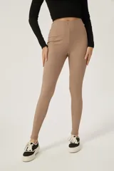 Calza ajustada de tiro alto, color camel, con textura acanalada vertical.