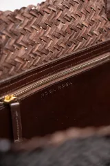 Cartera tote de cuero vacuno trenzado a mano, color bordó, de diseño espacioso con asas firmes.
