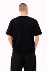 Remera negra de manga corta, corte holgado, con cuello redondo y estampado frontal en color verde con gráficos y texto de estilo japonés.