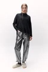 Sweater de lana color crema, de cuello alto y corte holgado.