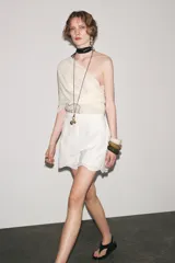 Bermuda negra de tiro alto confeccionada en hilatura de algodón con bordados perforados a tono, forro interior y cierre con cremallera oculta en costura.