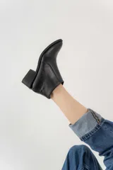 Botas cortas de cuero color marrón claro, con puntera fina y taco bajo de madera.