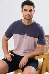 Remera de algodón y poliéster de corte clásico, con diseño en bloques de color negro en la parte superior y gris melange en la inferior. Presenta cuello redondo, mangas cortas y un pequeño estampado tipográfico en el pecho.