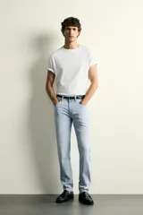 Jeans slim fit de tiro medio, color celeste claro con efecto lavado. Confeccionados en tejido elástico, cuentan con diseño de cinco bolsillos y cierre frontal con cremallera y botón metálico.