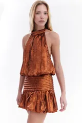 Top metalizado color cobre, con cuello halter y diseño balloon con caída fluida.