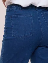 Jean straight elastizado de tiro medio, color azul, con bolsillos delanteros y traseros, pretina con pasadores, cierre y botón.
