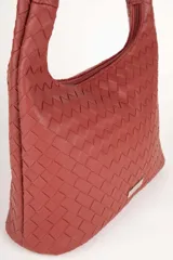 Cartera marrón de símil cuero trenzado con asa fija anudada. Cuenta con tres bolsillos interiores.