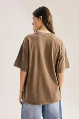 Remera marrón oversize con cuello redondo, mangas cortas y estampa gráfica frontal de diseño técnico con textura.