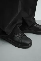Zapatilla urbana monocolor blanca con cordones al tono, diseño de parte superior lisa, puntera redondeada y suela con volumen.