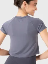 Remera de manga corta color gris acero, confeccionada en tela ultrasuave, con diseño de costura frontal fruncida que aporta un toque moderno y femenino.
