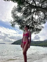 Conjunto de bikini fucsia con detalles en rosa, compuesto por un corpiño triangular fijo con abertura para agregar tazas soft y una bombacha colaless regulable.