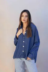 Camisa de denim suave con lavado clásico, corte oversize, cuello camisero y cierre frontal con botones a contraste.