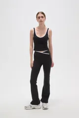 Calza flare de poliamida color negro, con diseño de tiro bajo y detalle de costura cruzada en la cintura.