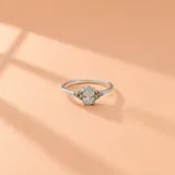 Anillo de plata 925 con piedra circonia central de corte ovalado en engarce de cuatro puntas, acompañado de pequeñas circonias laterales.