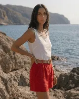 Short de lino color azul marino, de tiro alto, con bolsillos laterales y e incluye un cinto de rafia con hebilla redonda.